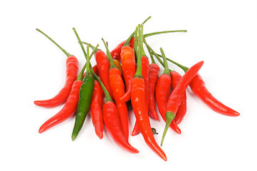 Image showing One Green between red chili peppers