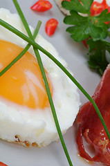 Image showing Fried Eggs Sunny Side Up with greens and bacon