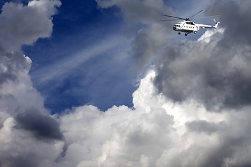 Image showing Helicopter in blue sky with clouds