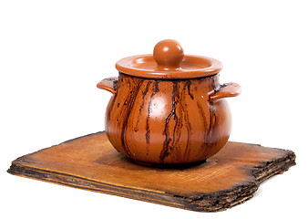 Image showing Dirty ceramic pot on old kitchen board