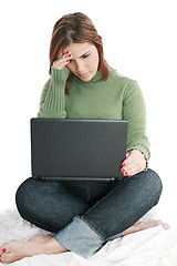 Image showing Pretty woman deep in thought while looking at laptop 