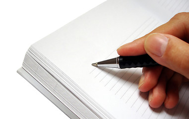 Image showing pen in hand writing on the notebook