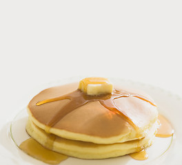 Image showing Golden pancakes with butter and warm maple syrup
