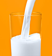 Image showing pouring milk in a glass isolated