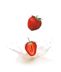 Image showing Strawberry falls into milk causing splash and drops