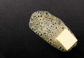 Image showing Piece of butter melting on non-stick frying pan