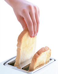 Image showing hand catches toast bread slices flying out of a toaster