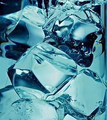 Image showing A background of bubbles forming in blue water after ice cubes