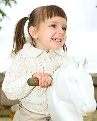 Image showing Little girl is swinging on see-saw