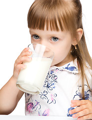 Image showing Cute little girl drinks milk