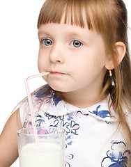 Image showing Cute little girl drinks milk using drinking straw