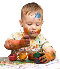 Image showing Little boy is playing with paints