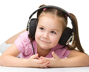 Image showing Cute little girl enjoying music using headphones