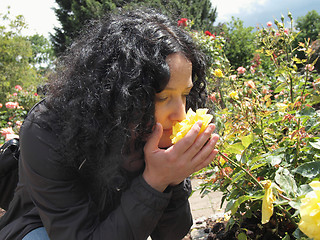 Image showing Pretty brunette smelling roses