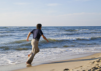 Image showing Man running along seashore