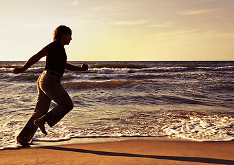 Image showing Man running along seashore