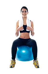 Image showing Attractive female athlete sitting on blue ball
