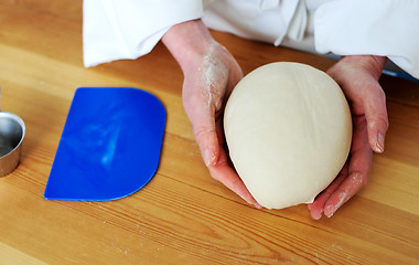 Image showing Chefs hand holding a clean finished dough