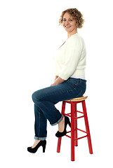 Image showing Confident senior woman resting on stool