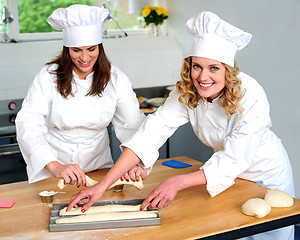 Image showing Female chef arranging prepared dough