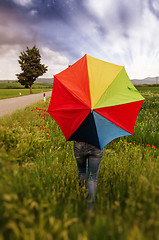 Image showing Girl with umbrella at field with Dramatic Sky