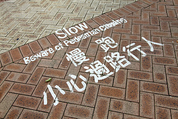 Image showing Slow beware of pedestrian crossing on the ground