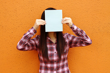 Image showing Asian woman using book to cover face