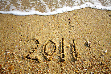 Image showing 2011 written on sand