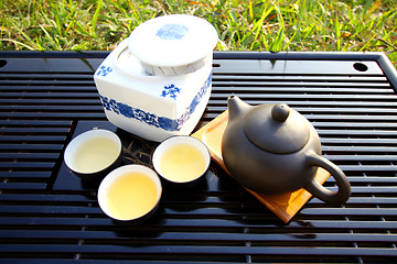 Image showing Asian tea set on grasses