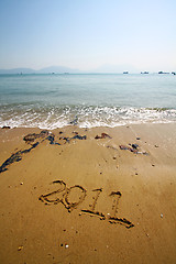 Image showing 2011 written on sand