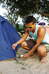 Image showing Asian man set up tent in camping