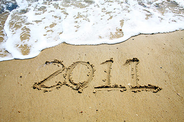 Image showing 2011 written on sand