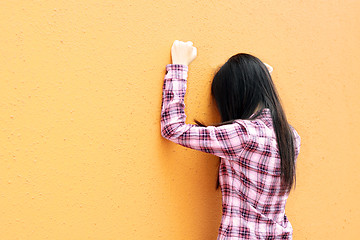 Image showing Asian woman very sad and facing the wall
