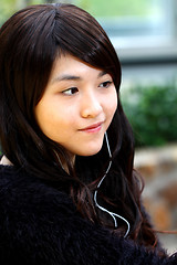 Image showing Asian woman listening music