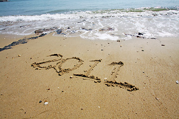 Image showing 2011 written on sand