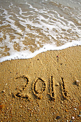 Image showing 2011 written on sand