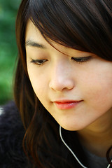 Image showing Asian woman listening music