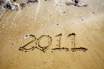 Image showing 2011 written on sand