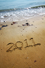 Image showing 2011 written on sand