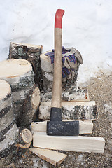 Image showing Ax, a pile of birch firewoods and glove