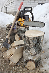 Image showing Firewood and chainsaw with gloves