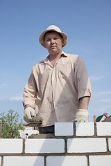 Image showing Bricklayer builds a wall