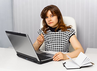 Image showing Young businesswoman sitting at a desk