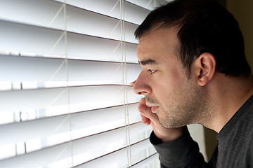 Image showing Man Peeking Through Blinds