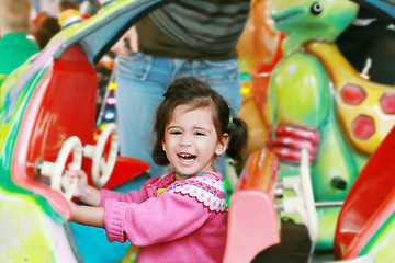 Image showing little girl playing on carousel 