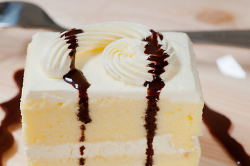 Image showing fresh cream cake closeup with chocolate sauce