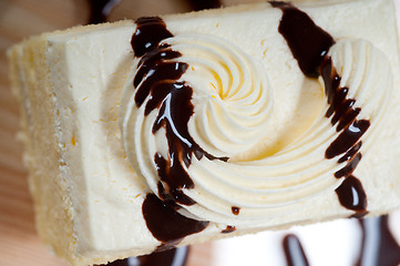 Image showing fresh cream cake closeup with chocolate sauce