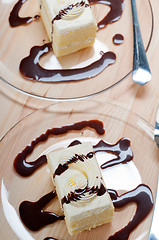 Image showing fresh cream cake closeup with chocolate sauce