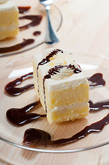 Image showing fresh cream cake closeup with chocolate sauce