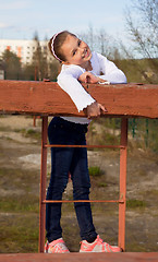 Image showing A girl in jeans and sneakers to the playground